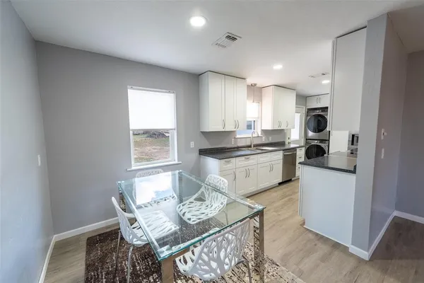 a large kitchen with stainless steel appliances granite countertop a sink a stove and a refrigerator