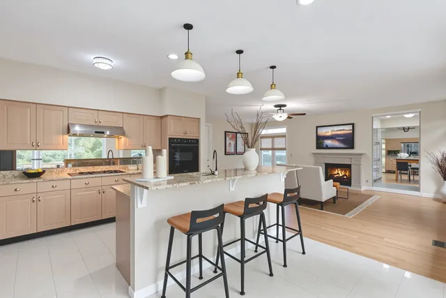 a kitchen with cabinets a sink and chairs