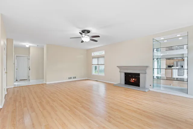 a view of empty room with wooden floor and fireplace