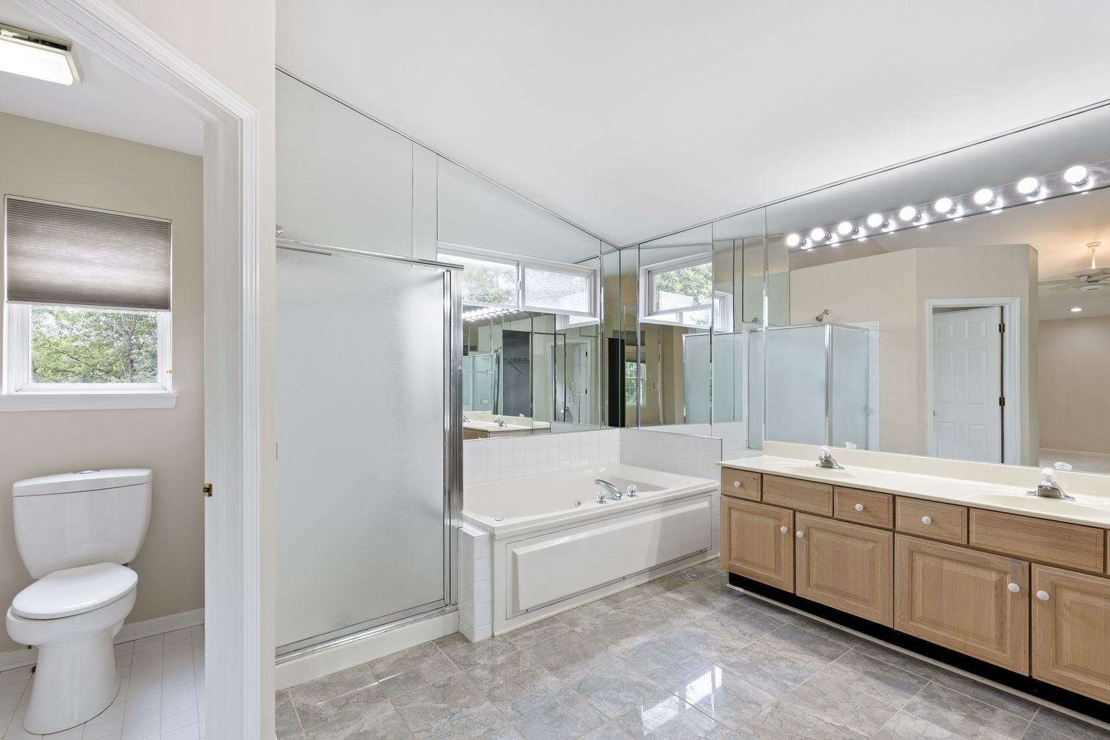 7623 Beringer Court Gurnee, IL 60031 - Photo 16 of 28 a bathroom with a double vanity sink a toilet a mirror and shower