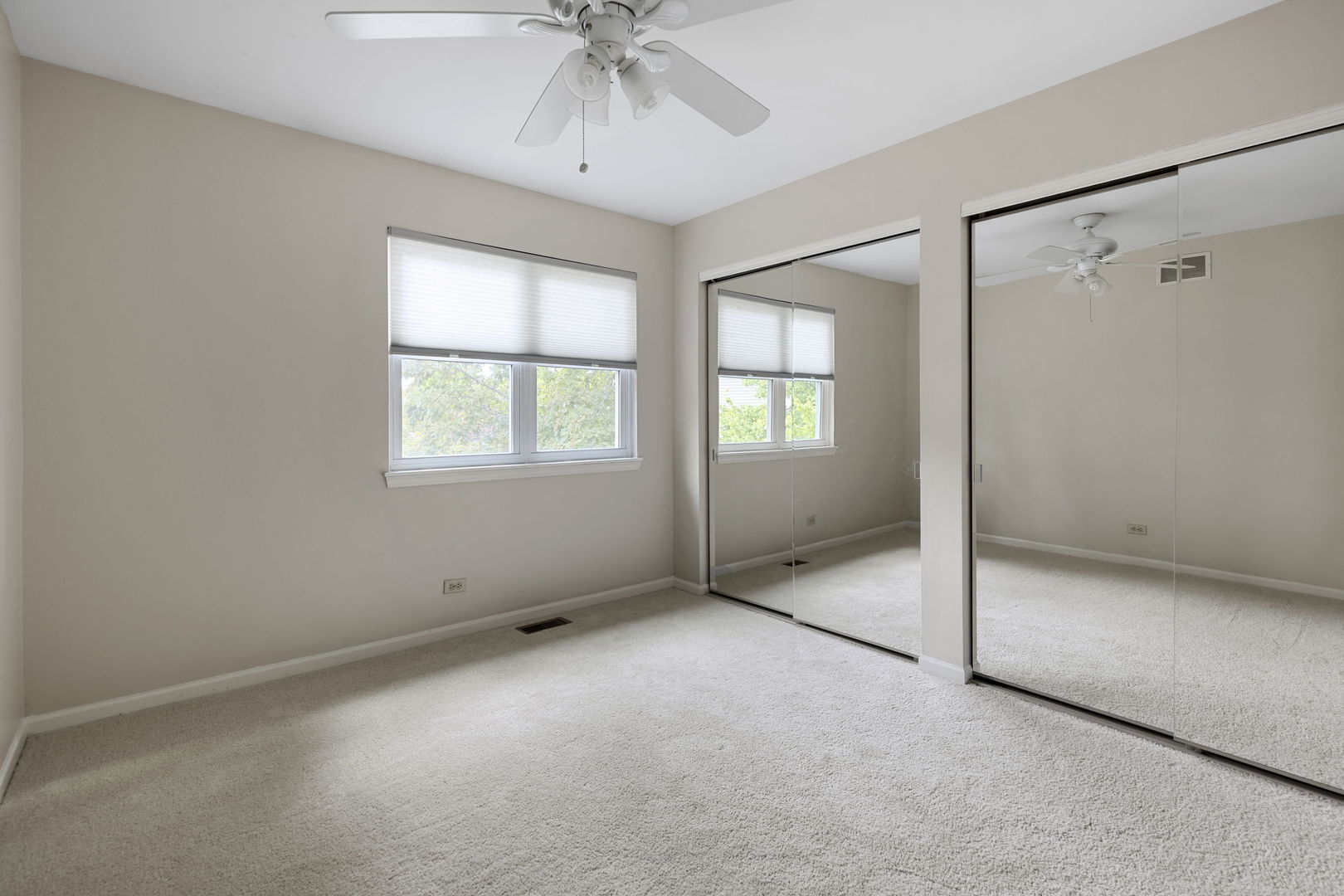 7623 Beringer Court Gurnee, IL 60031 - Photo 19 of 28 an empty room with chandelier fan and windows