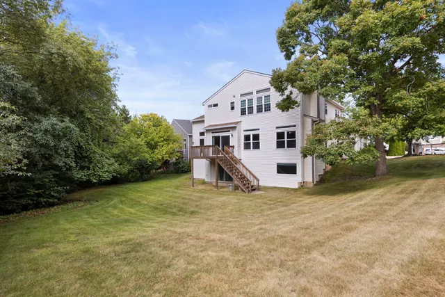 a view of a house with backyard and trees
