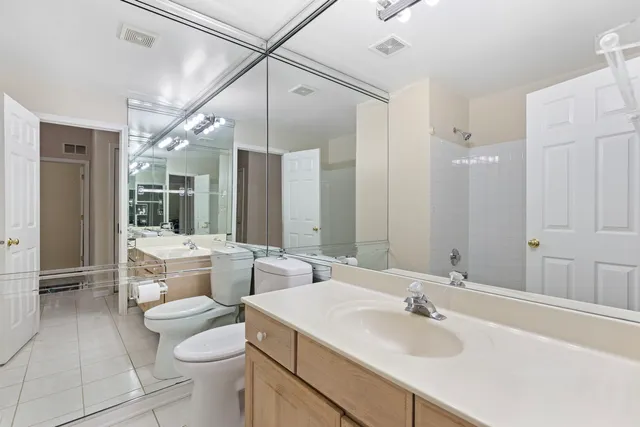 a bathroom with a double vanity sink toilet and shower