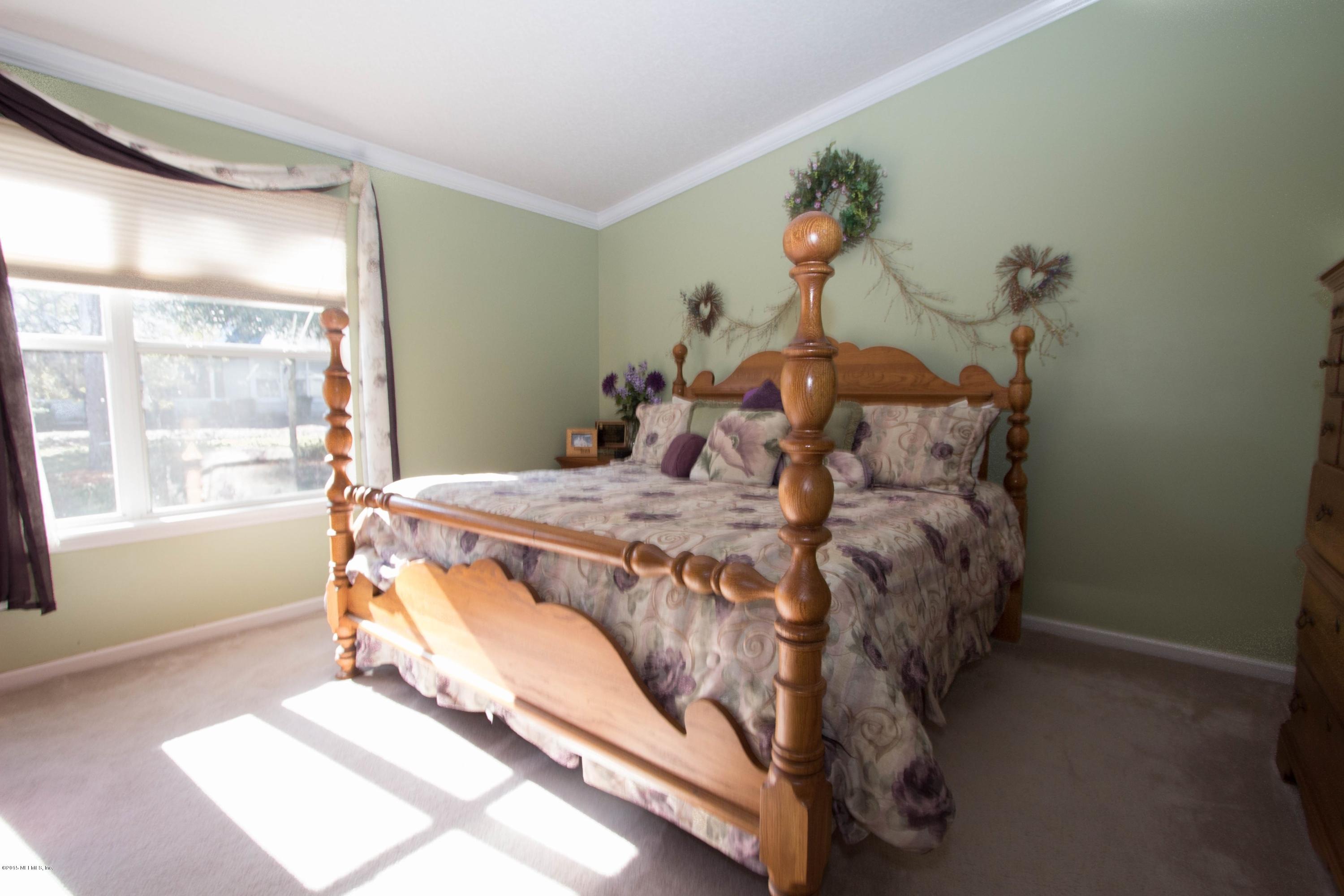3140 Ravines Road Middleburg, FL 32068 - Photo 11 of 28 a bed sitting in a bedroom next to a window