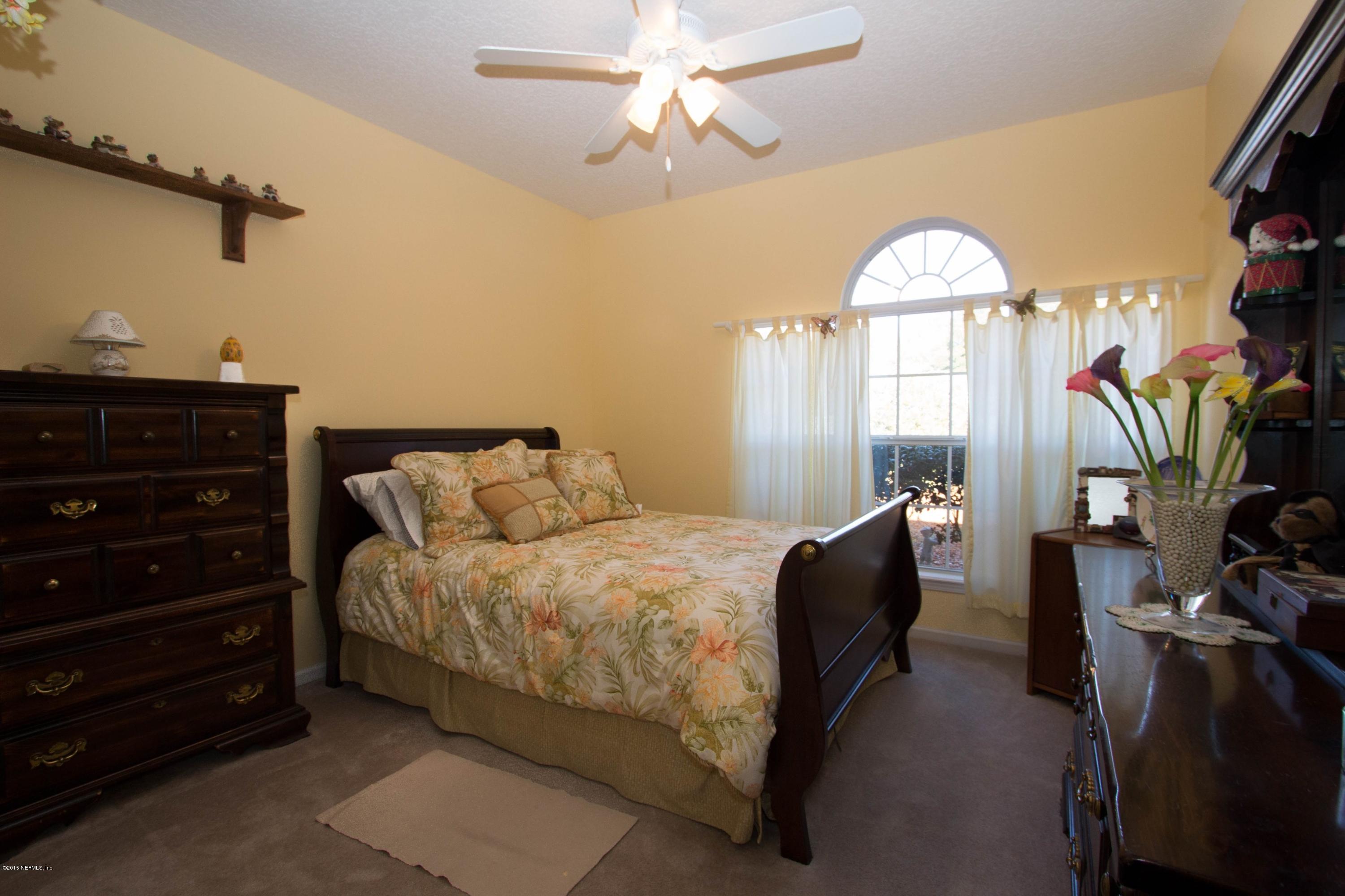 3140 Ravines Road Middleburg, FL 32068 - Photo 15 of 28 a bedroom with a bed and a chandelier