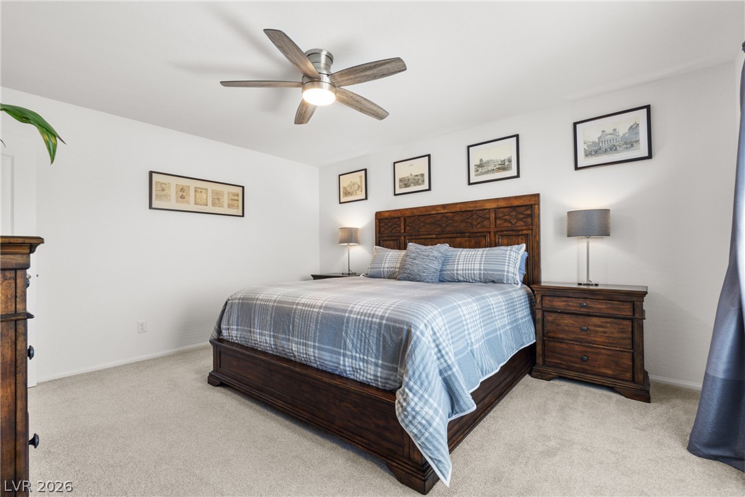 891 Earth Luster Road Las Vegas, NV 89178 - Photo 12 of 48 A tranquil bedroom provides comfort with soft carpeting and a modern ceiling fan for climate control.