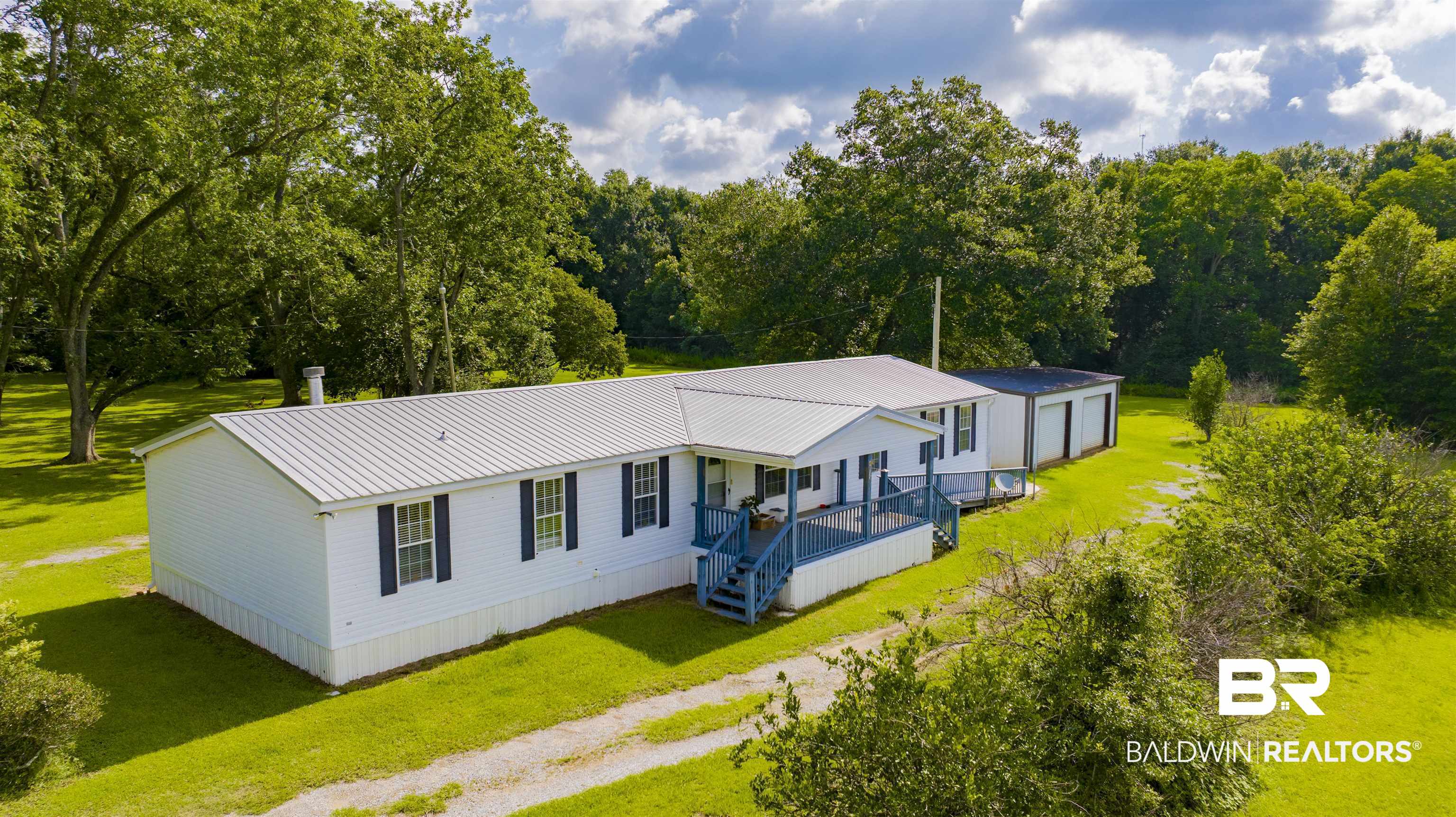 25700 County Road 71 Robertsdale, AL 36567 - Photo 35 of 40 View of front of home with a front lawn, driveway, a metal roof, and a garage