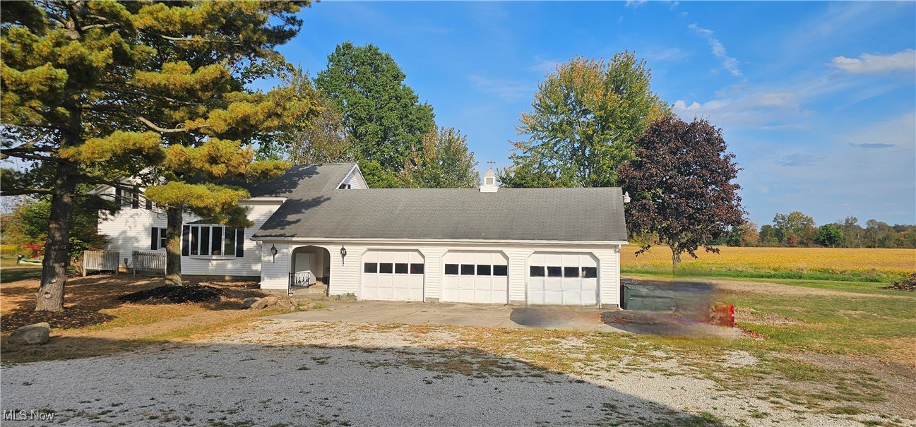 6162 Spieth Road Medina, OH 44256 - Photo 6 of 14 View of west side of the house showing the breezeway, the 3 car garage, part of the rear yard and the soy bean field next door.
