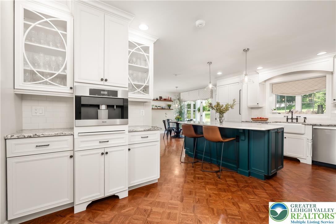 1588 Surrey Road Bethlehem, PA 18015 - Photo 11 of 50 a kitchen with stainless steel appliances kitchen island granite countertop a stove a sink and white cabinets with wooden floor