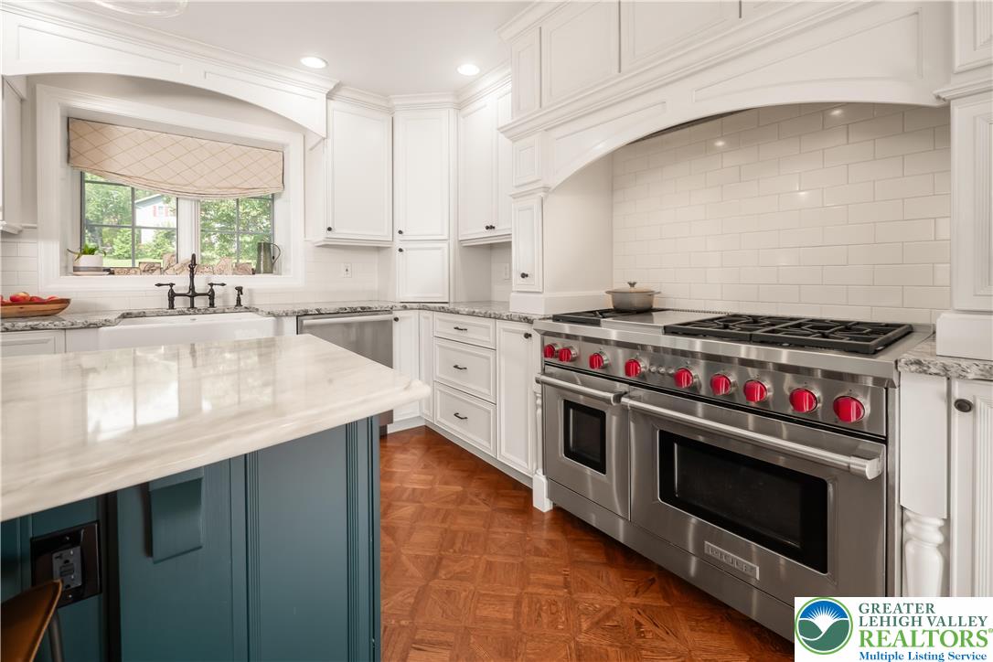 1588 Surrey Road Bethlehem, PA 18015 - Photo 14 of 50 a kitchen with stainless steel appliances a stove a sink and a wooden cabinets