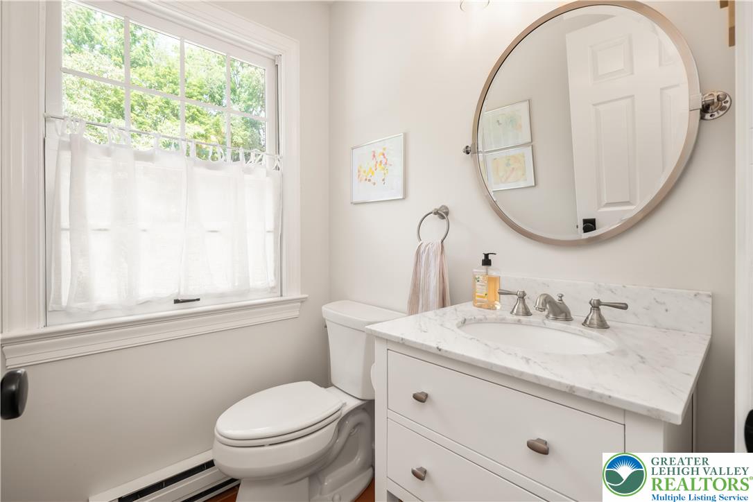1588 Surrey Road Bethlehem, PA 18015 - Photo 39 of 50 a bathroom with a toilet a sink a mirror and a window