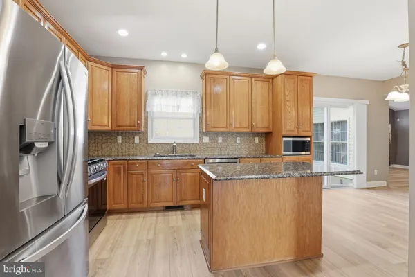 a view of a livingroom with a fireplace a ceiling fan and windows