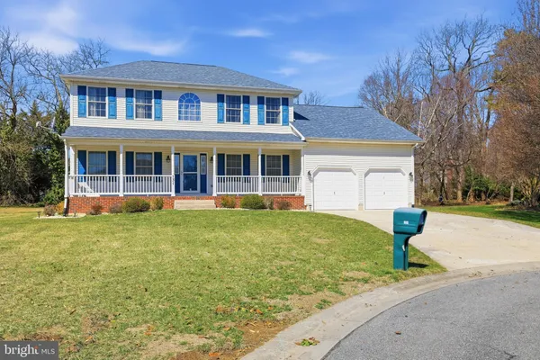 a front view of a house with yard porch and tree