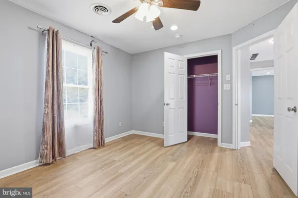 a view of empty room with wooden floor and cabinet