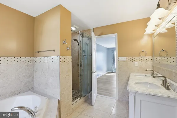 a spacious bedroom with a large bed and a chandelier