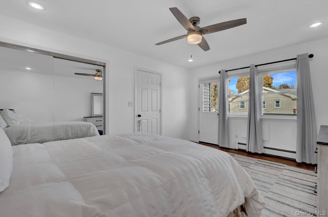 83 Finch Lane, Unit 2B Islip, NY 11751 - Photo 12 of 18 a spacious bedroom with a bed and a ceiling fan