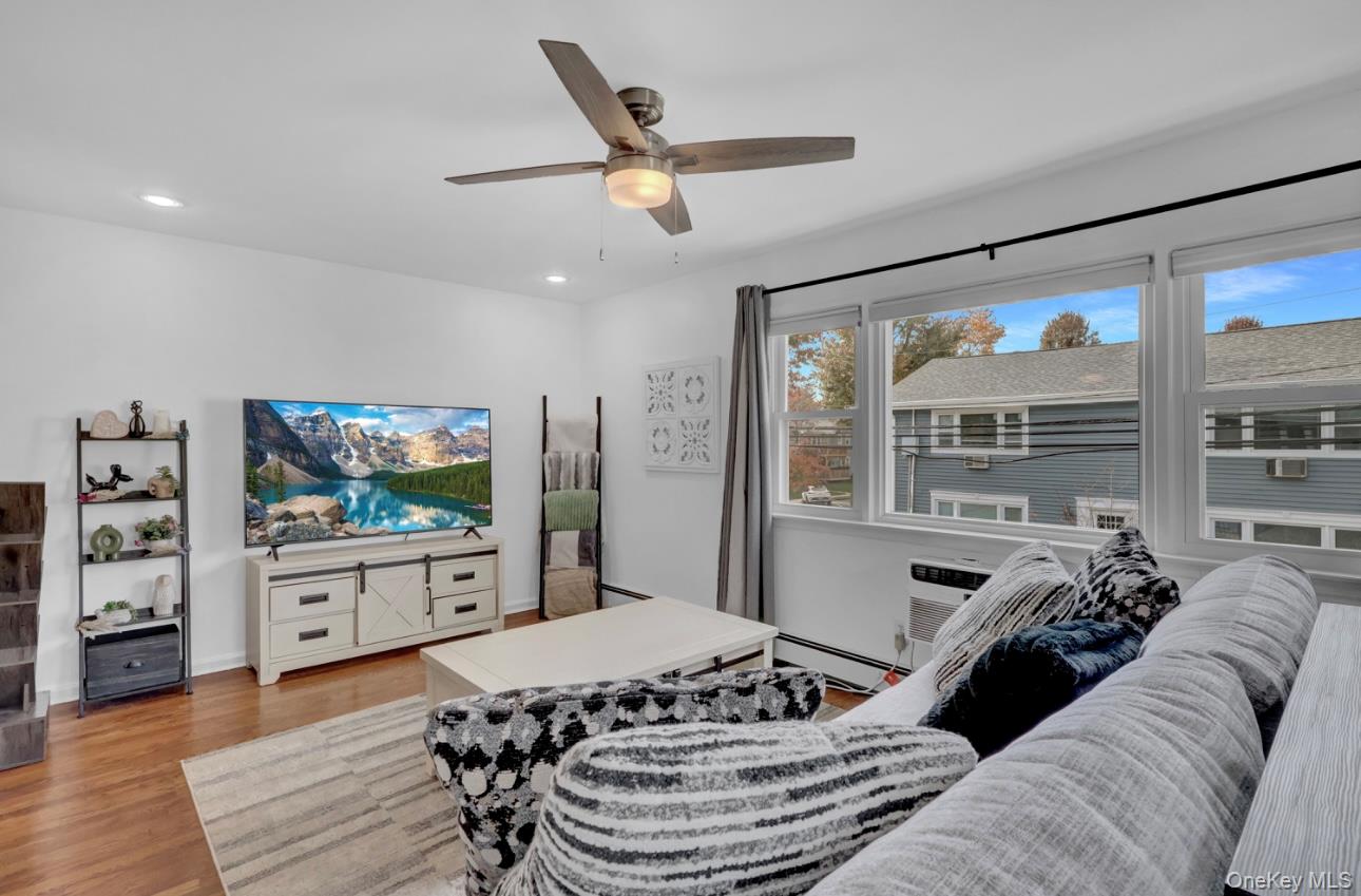 83 Finch Lane, Unit 2B Islip, NY 11751 - Photo 7 of 18 a living room with furniture and a flat screen tv