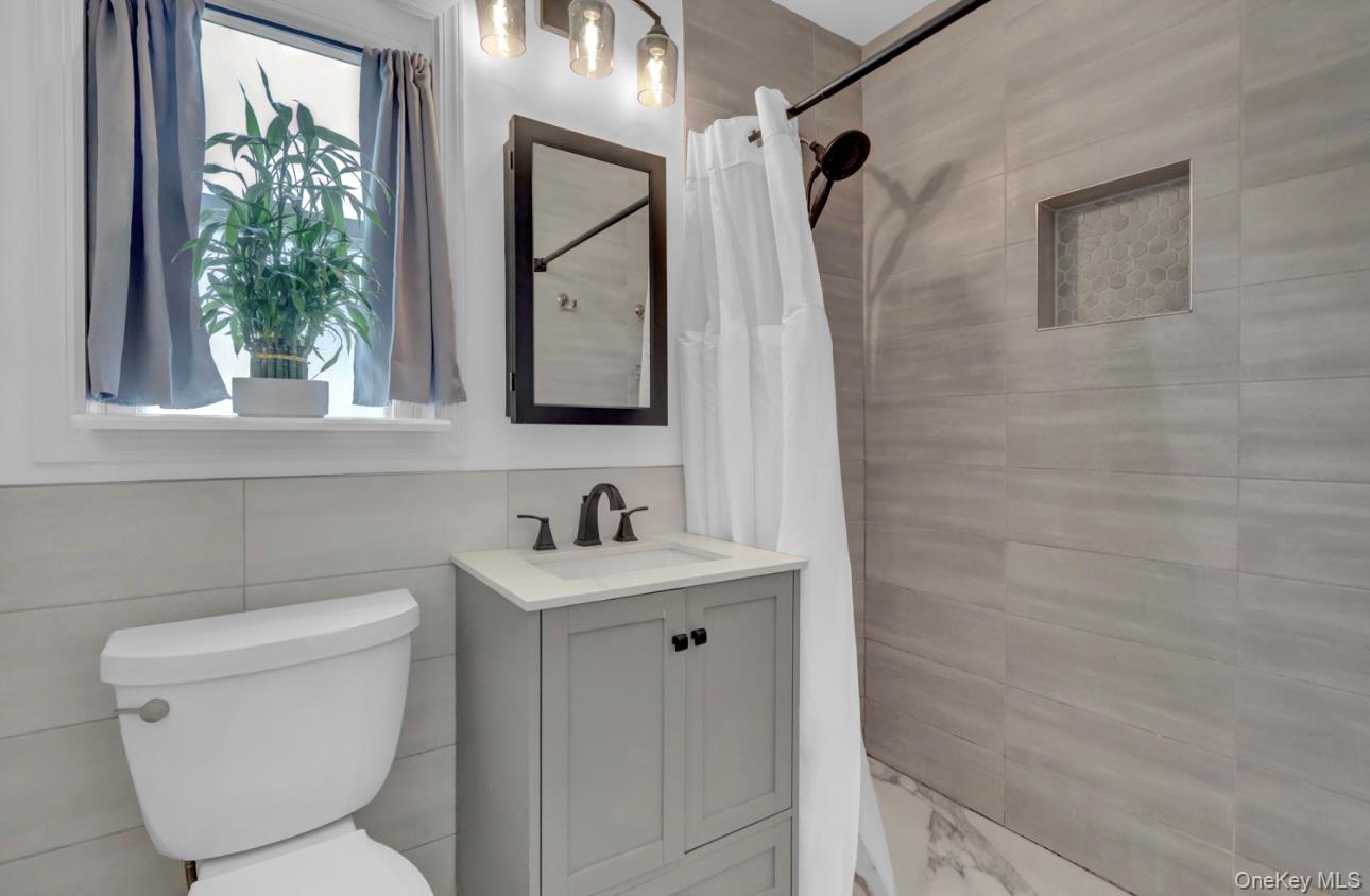 83 Finch Lane, Unit 2B Islip, NY 11751 - Photo 10 of 18 a bathroom with a toilet sink and mirror