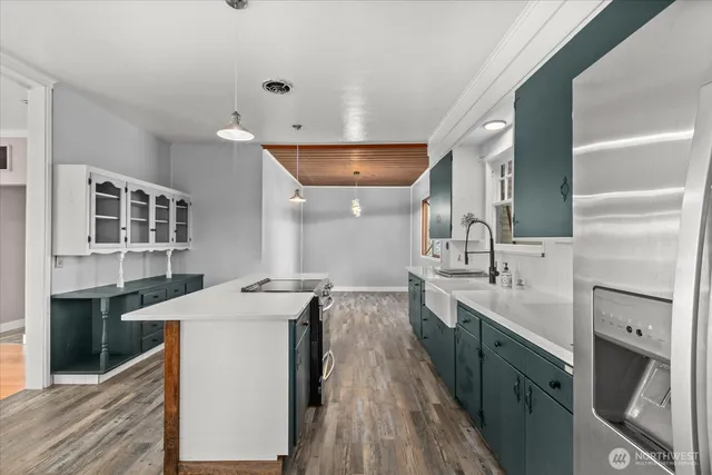 a kitchen with stainless steel appliances kitchen island a sink stove and cabinets