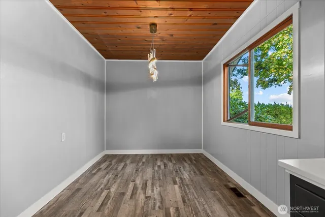 a view of a hallway with wooden floor and a window