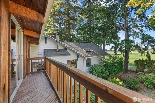 a view of a brick house with a large window and potted plants