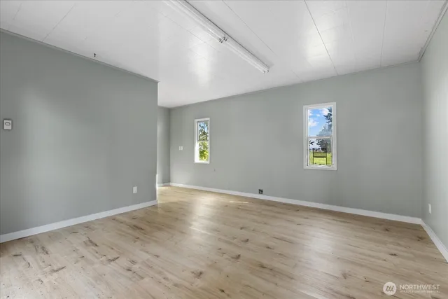 a view of a room with wooden floor and windows