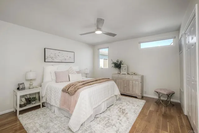 a bedroom with a large bed and a chandelier fan