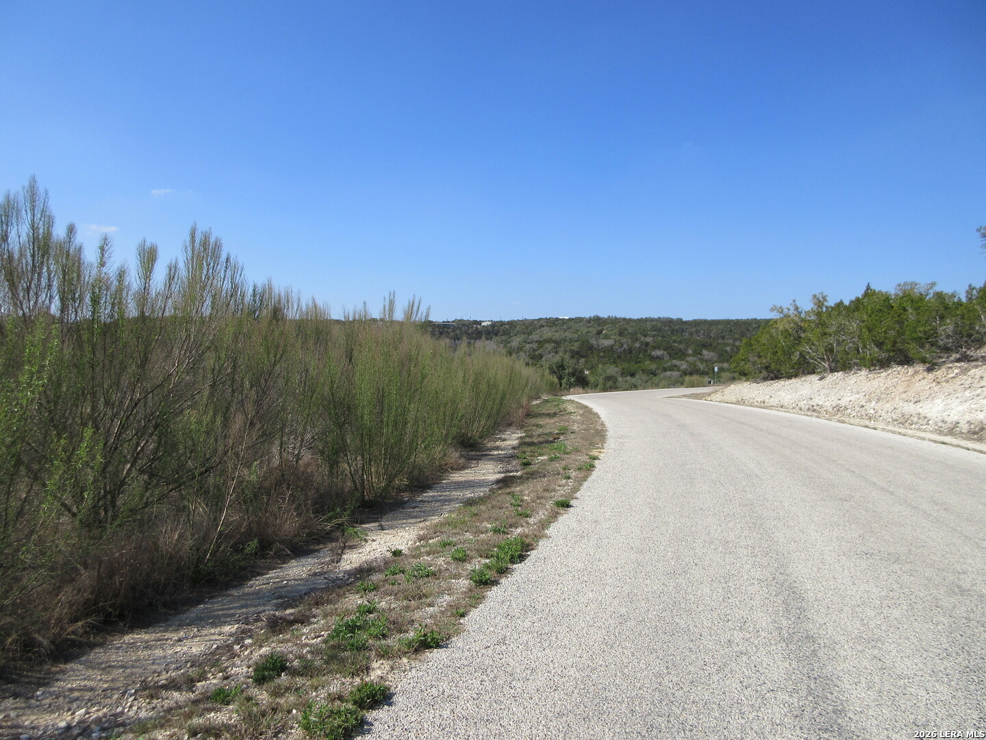 Lot 13 Canyon Rim Helotes, TX 78023 - Photo 5 of 5 a view of a pathway both side of grassy field with trees in background