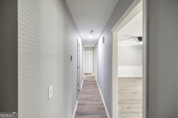 a view of a hallway with wooden floor and staircase