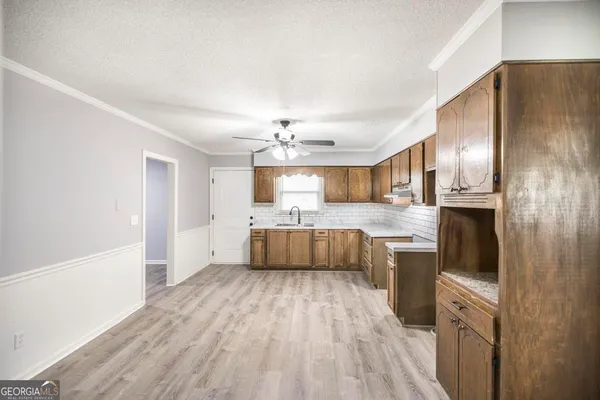 a large kitchen with a lot of cabinets and wooden floor