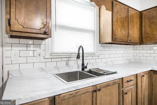 a kitchen with granite countertop a sink a stove and cabinets