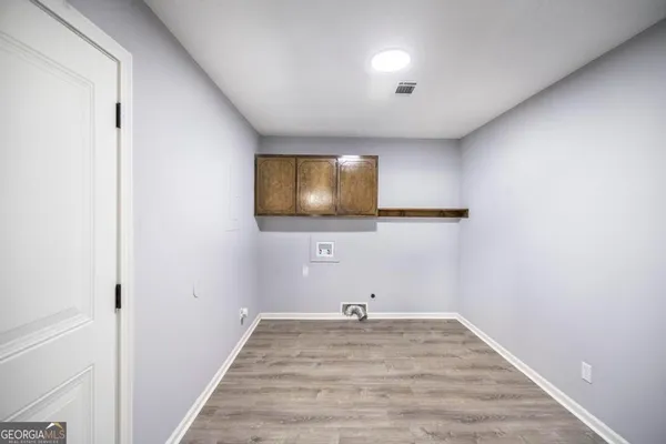 a view of a livingroom with wooden floor and a flat screen tv