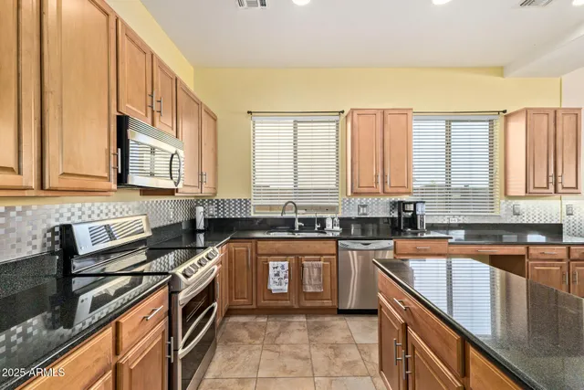 a kitchen with stainless steel appliances granite countertop a sink stove and cabinets