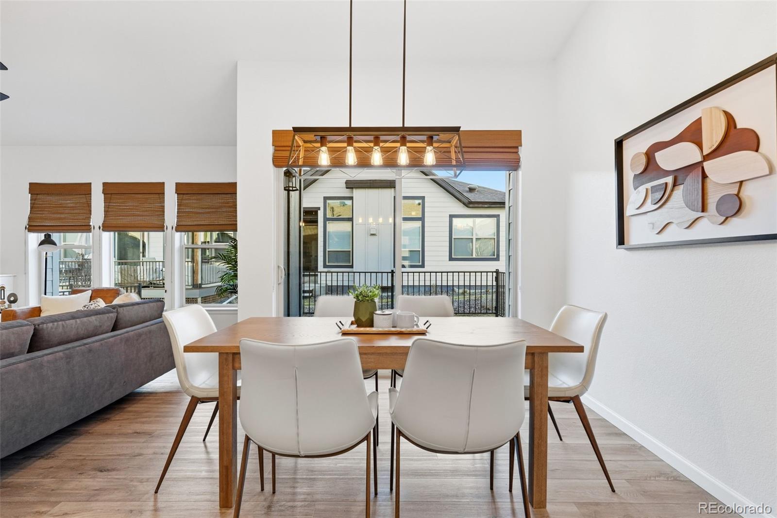 8283 South Queen Street Littleton, CO 80127 - Photo 13 of 46 a dining room with furniture a chandelier and wooden floor