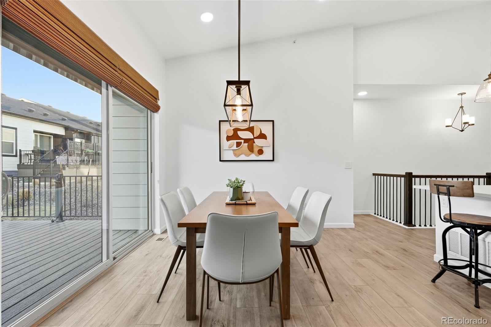 8283 South Queen Street Littleton, CO 80127 - Photo 14 of 46 a dining room with furniture a chandelier and wooden floor
