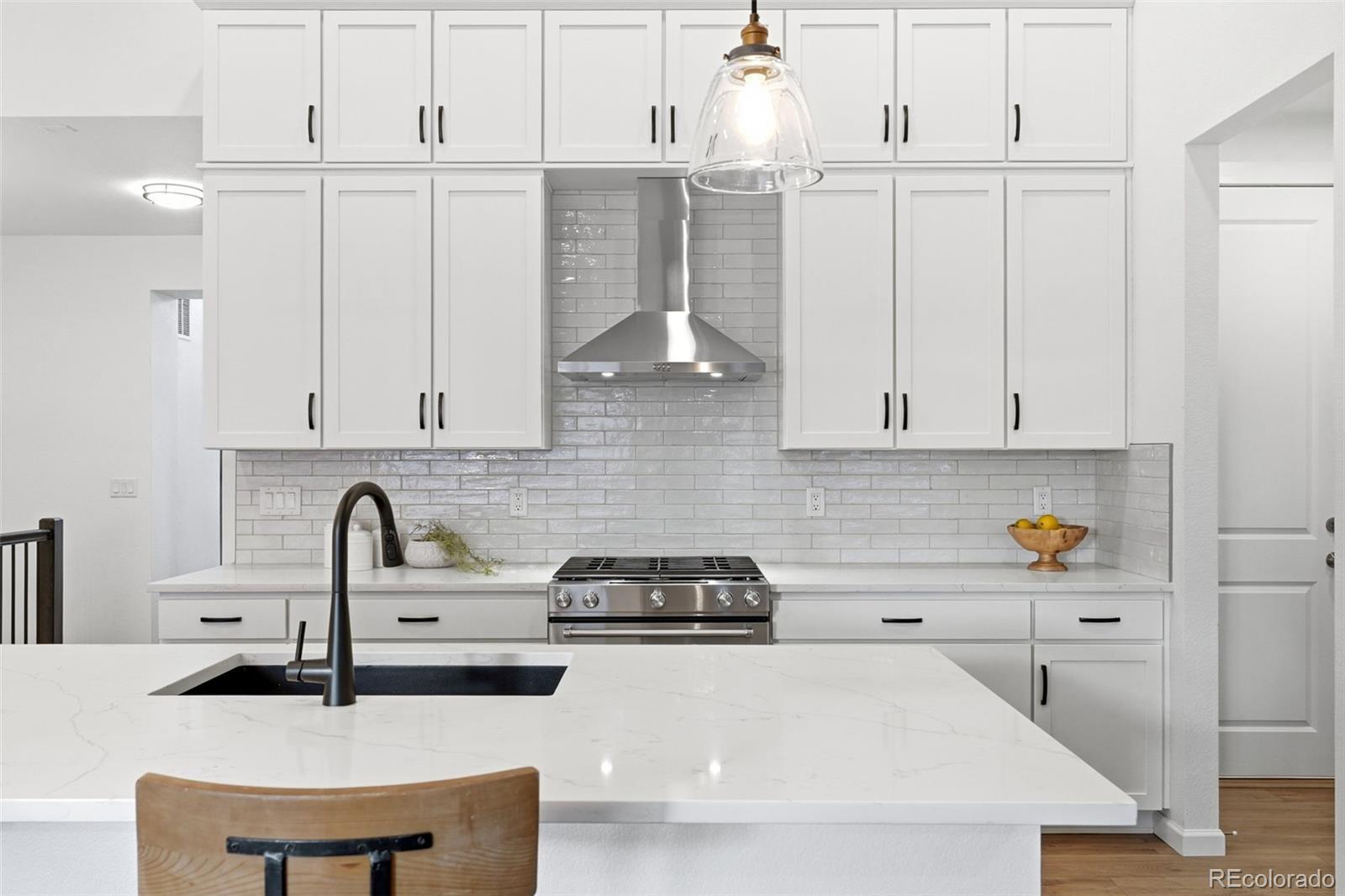 8283 South Queen Street Littleton, CO 80127 - Photo 16 of 46 a kitchen with granite countertop a sink a stove and cabinets