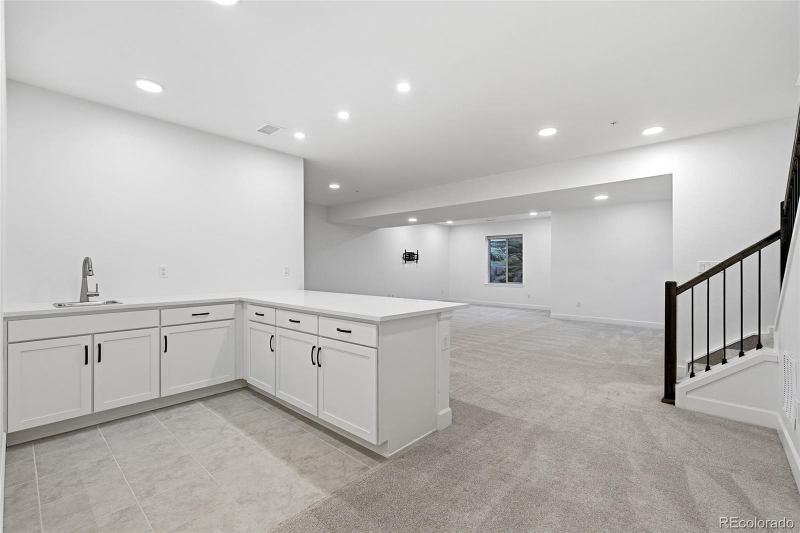 8283 South Queen Street Littleton, CO 80127 - Photo 34 of 46 a large white kitchen with a sink