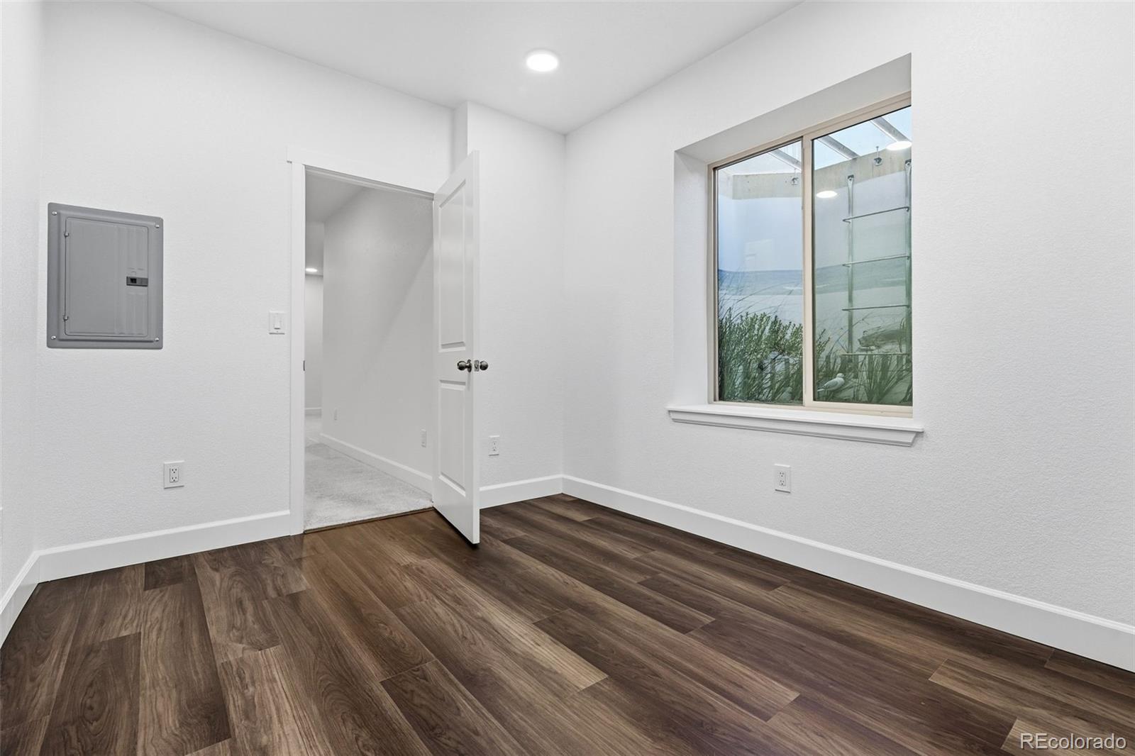 8283 South Queen Street Littleton, CO 80127 - Photo 35 of 46 an empty room with wooden floor and windows