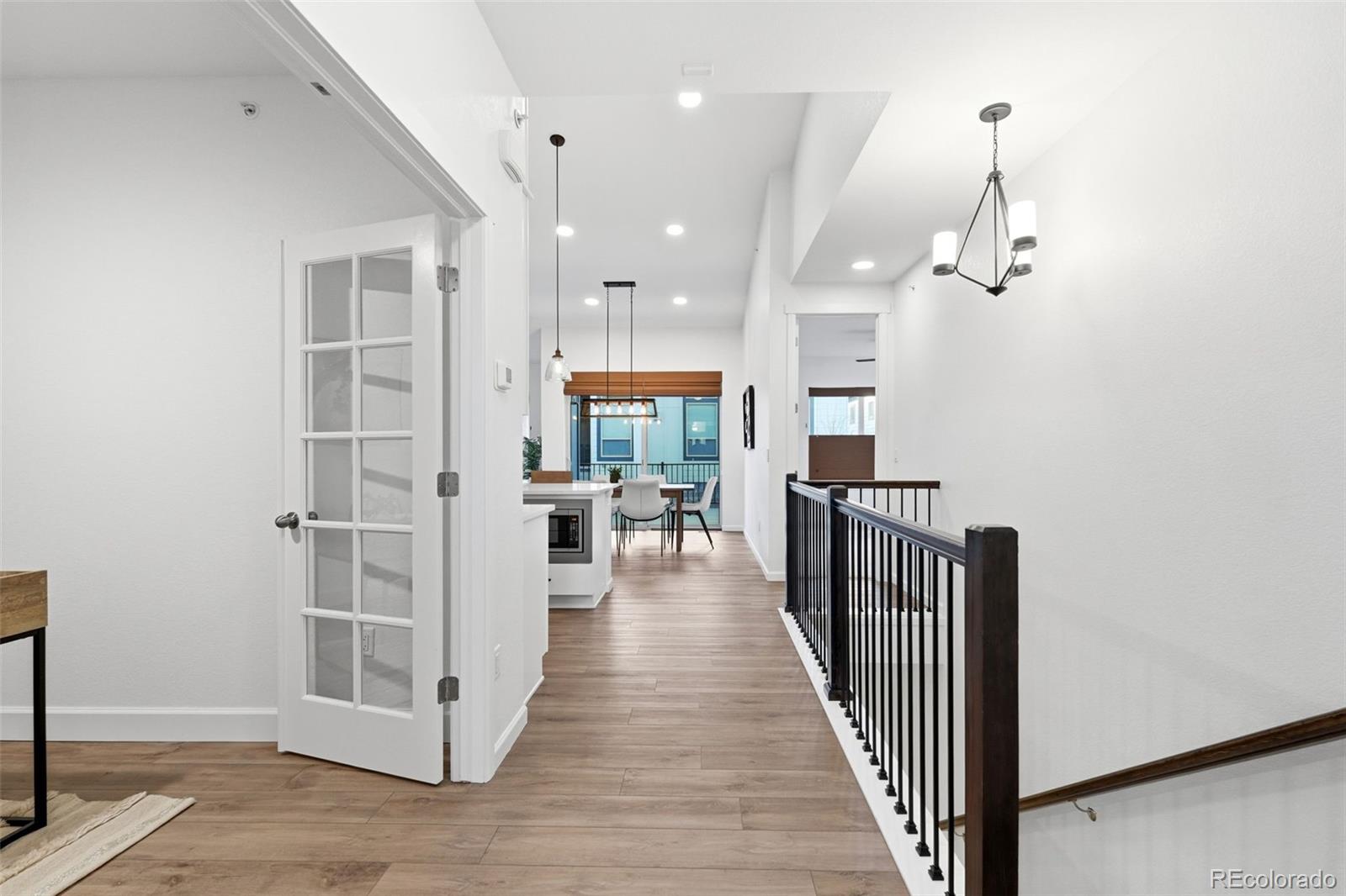 8283 South Queen Street Littleton, CO 80127 - Photo 7 of 46 a view of a hallway with wooden floor and a kitchen
