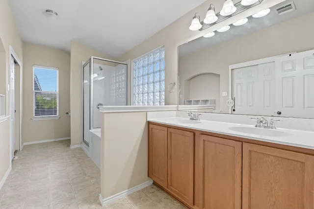 a bathroom with a double vanity sink and a mirror