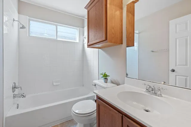 a bathroom with a granite countertop sink a toilet and bathtub