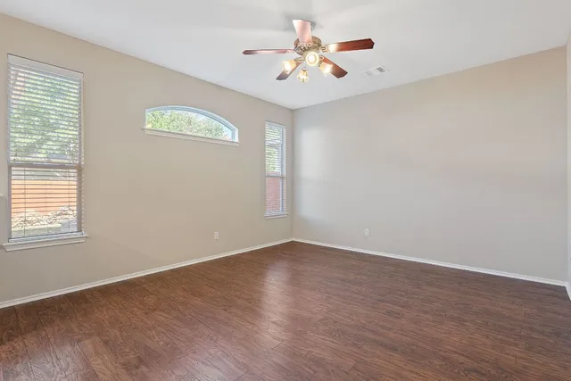 wooden floor in an empty room with a window