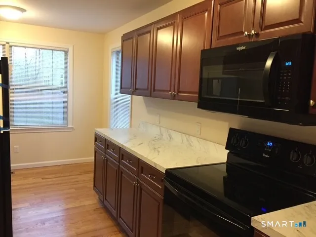 a kitchen with stainless steel appliances granite countertop a stove a sink and a microwave