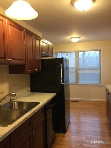 a kitchen with granite countertop a refrigerator and a sink