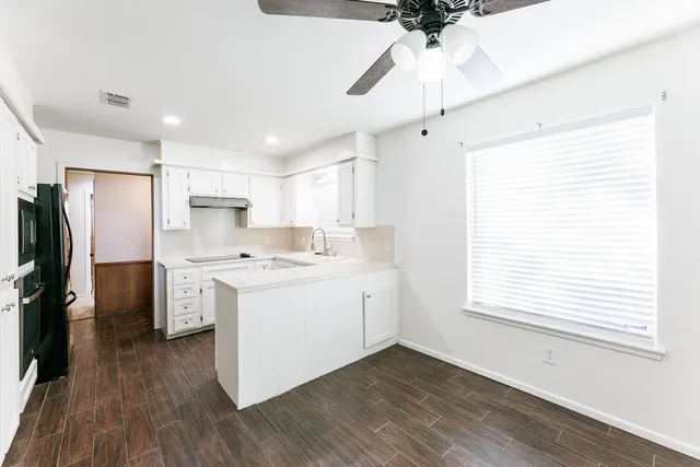 a kitchen with a refrigerator a stove and a wooden floor