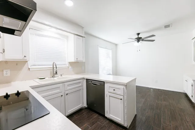 a kitchen with a sink cabinets appliances and a window