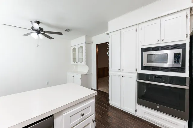 a kitchen with white cabinets stainless steel appliances and a refrigerator