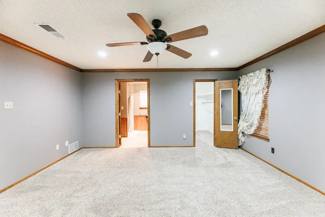 a view of an empty room with a ceiling fan