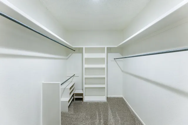 a view of walk in closet with empty racks