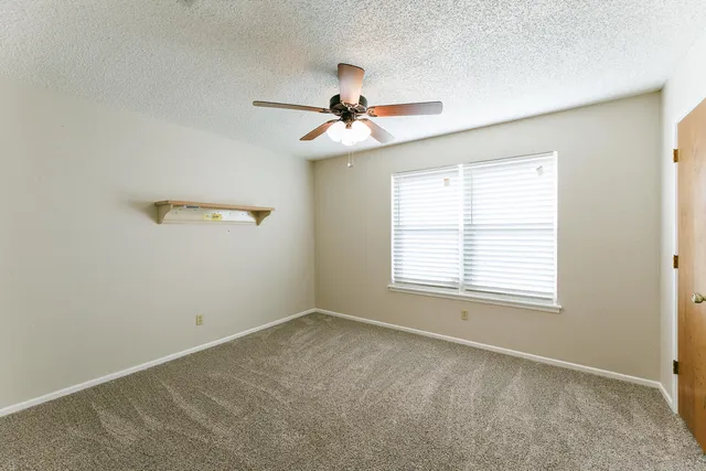 a view of a room with a ceiling fan and a window